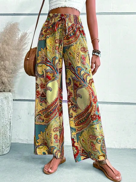 Wide palazzo pants for women with a colorful paisley pattern and an elastic waistband Lune London