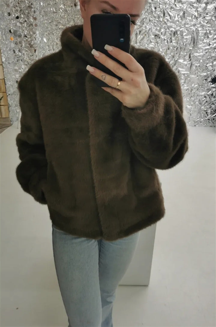 Fleece jacket for women with stand-up collar and side pockets with openings.