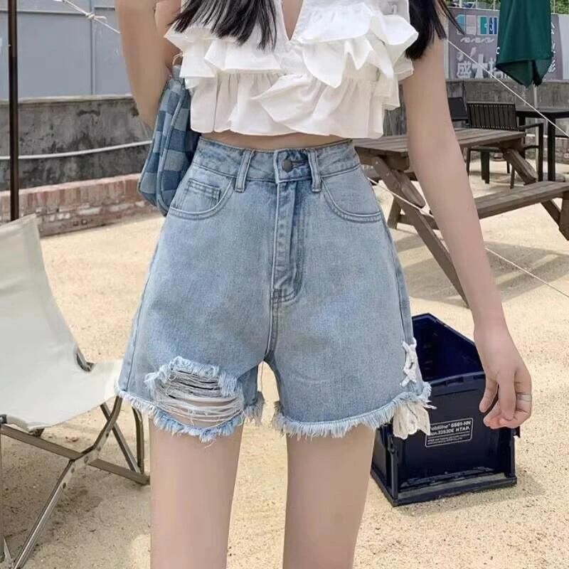 Ladies' denim shorts with trendy destroyed details and handcrafted accents