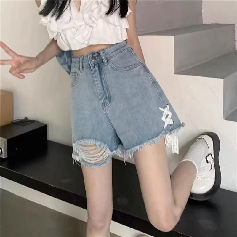 Ladies' denim shorts with trendy destroyed details and handcrafted accents