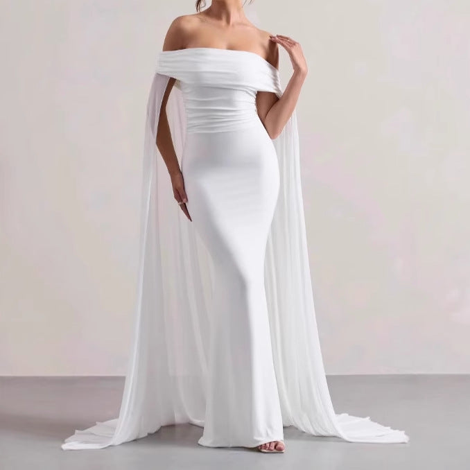 Elegant evening dress for women with off-the-shoulder design, flowing sheer cape, and flattering cut Lune London