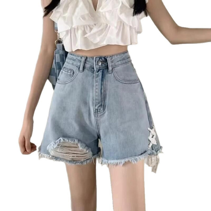 Ladies' denim shorts with trendy destroyed details and handcrafted accents