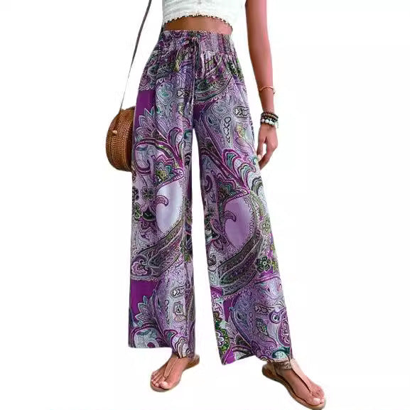 Wide palazzo pants for women with a colorful paisley pattern and an elastic waistband Lune London