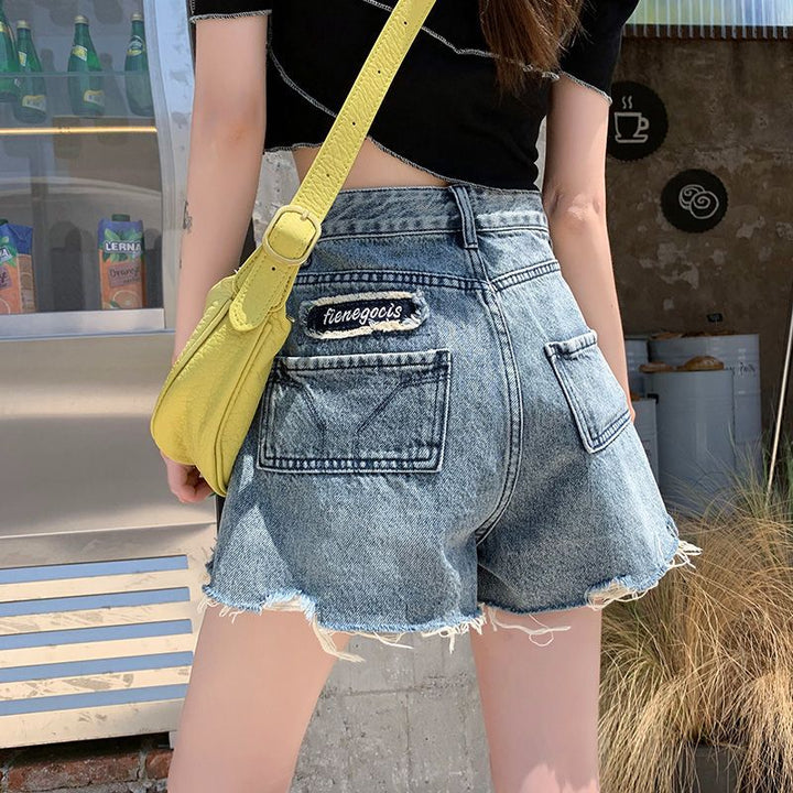 Women's denim shorts with frayed hems and unique embroidery detail Lune London