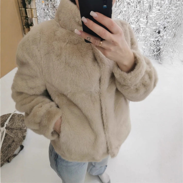 Fleece jacket for women with stand-up collar and side pockets with openings.