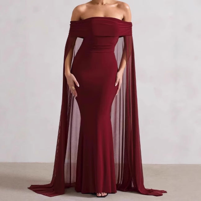 Elegant evening dress for women with off-the-shoulder design, flowing sheer cape, and flattering cut Lune London