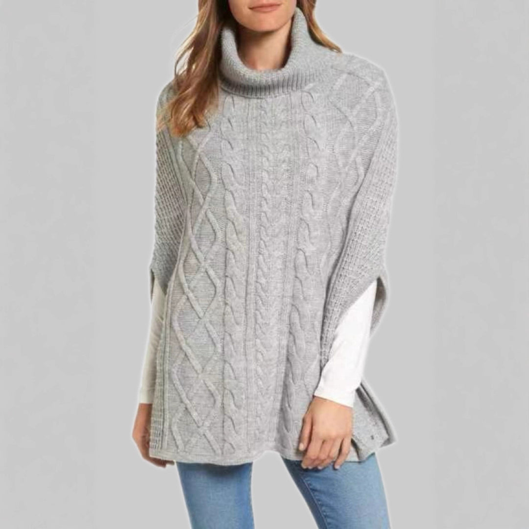 Knitted poncho for women with high collar and classic cable knit pattern Lune London
