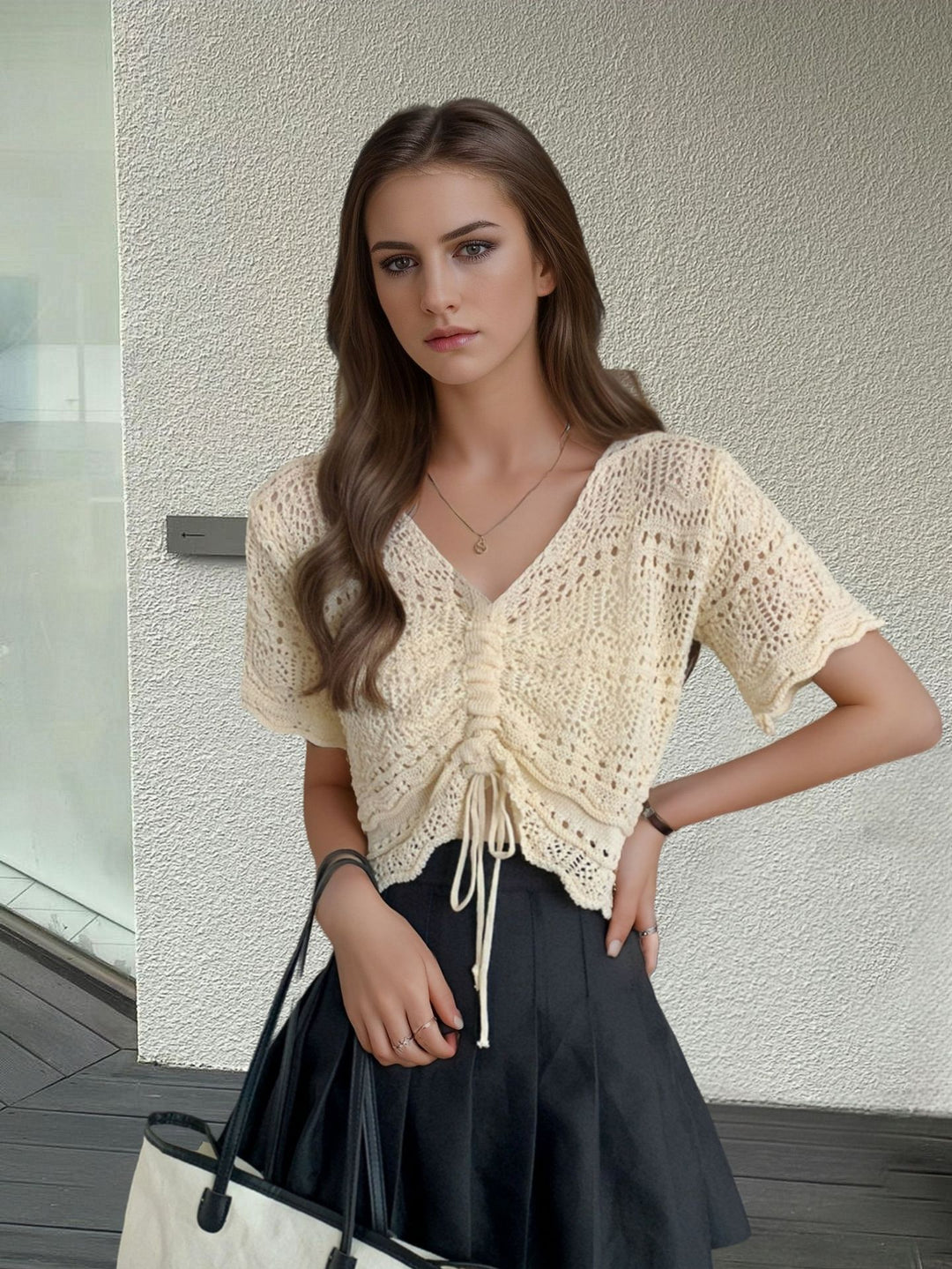 Women's knit top with decorative hole pattern and adjustable hem Lune London