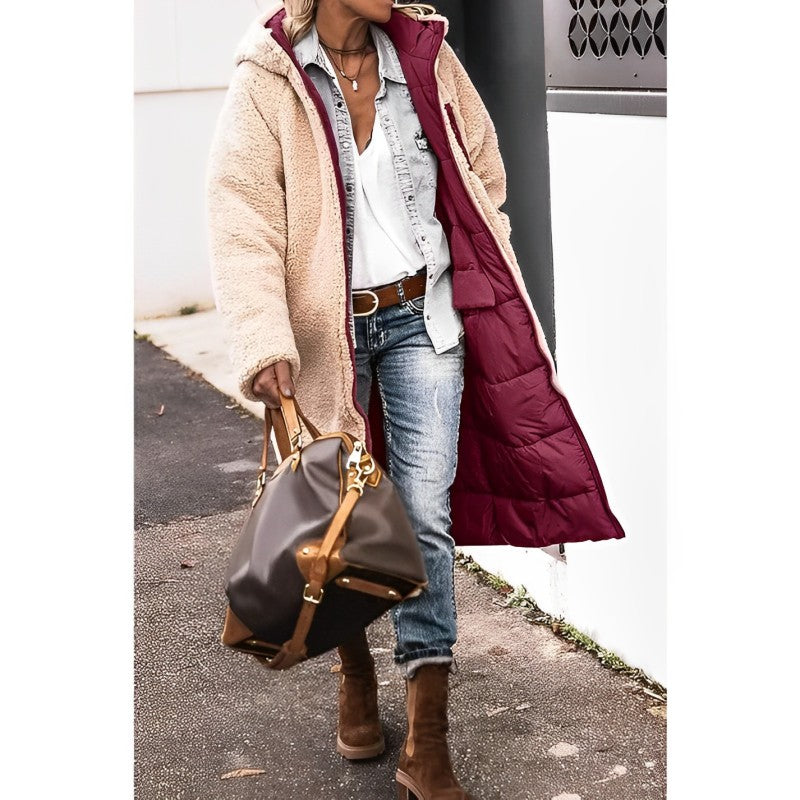 Eine frau in einem langer, bequemer mantel und jeans, die eine braune handtasche trägt